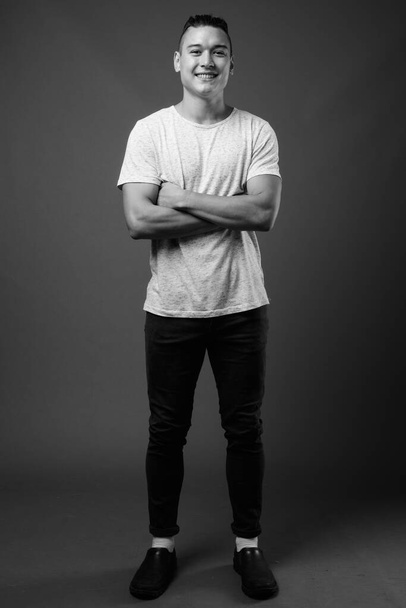 Studio shot de jeune homme multi ethnique beau sur fond gris en noir et blanc - Photo, image