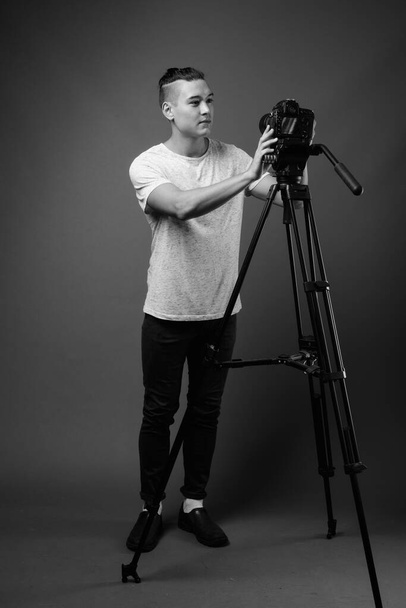 Студийный снимок молодого красивого мультиэтнического мужчины на сером фоне в черно-белом - Фото, изображение