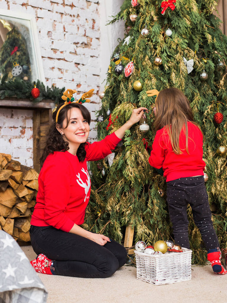 mother and daughter dress up a Christmas tree - Fotoğraf, Görsel