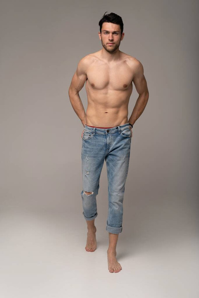 Portrait of a well built shirtless muscular male model against white background. - Фото, зображення
