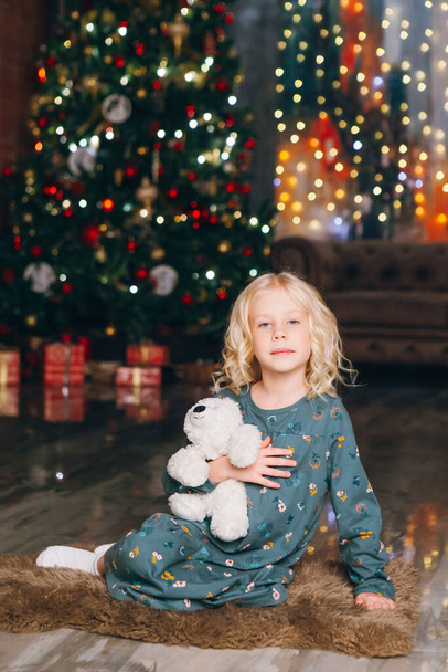Cute little blonde girl posing at the Christmas tree. Happy new year concept. Toning. - Foto, Imagem