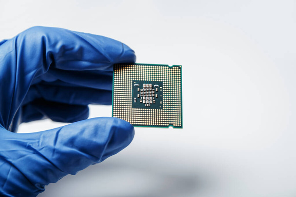 Vista de cerca de un nuevo microchip semiconductor en mano enguantada de un científico informático. Tecnología moderna y desarrollo de hardware - Foto, Imagen