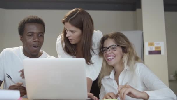 Χαρούμενοι συνάδελφοι που παρακολουθούν αστείο περιεχόμενο στο laptop - Πλάνα, βίντεο