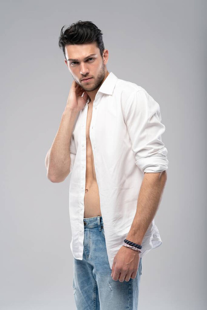 Portrait of a well built shirtless muscular male model against white background. - Valokuva, kuva