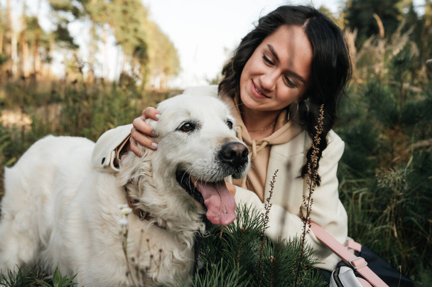 girl hugging a golden retriever dog in the field - Фото, зображення