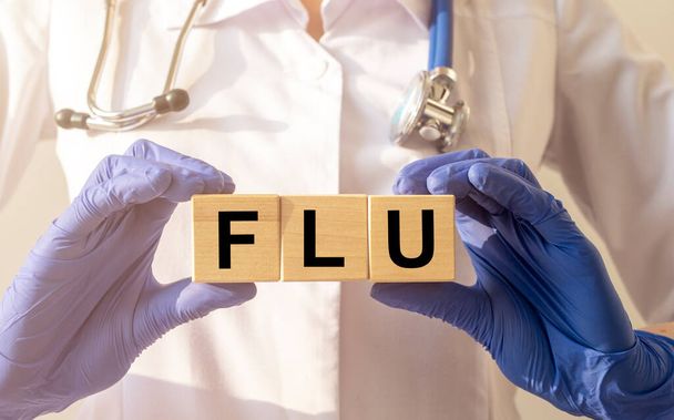 FLU the word is written on wooden cubes on doctor workplace. - Zdjęcie, obraz