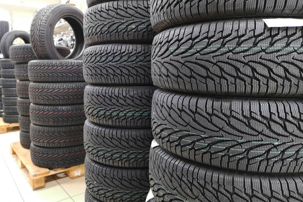 Neumáticos de coche en tienda de automóviles. Neumáticos en venta en una tienda de neumáticos - pilas de neumáticos nuevos. - Foto, imagen
