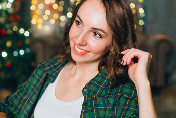 Young beautiful brunette woman at the Christmas tree. Happy new year concept. Toning. - Valokuva, kuva
