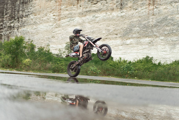 A man on a motorcycle doing stunts. on a motorcycle on one wheel. - Foto, afbeelding