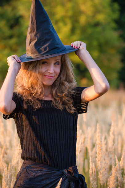 Mladá čarodějnice v klobouku při západu slunce - Fotografie, Obrázek