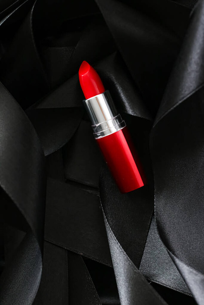 Κόκκινο κραγιόν σε μαύρο μεταξωτό φόντο, πολυτελές μακιγιάζ και καλλυντικών ομορφιάς - Φωτογραφία, εικόνα