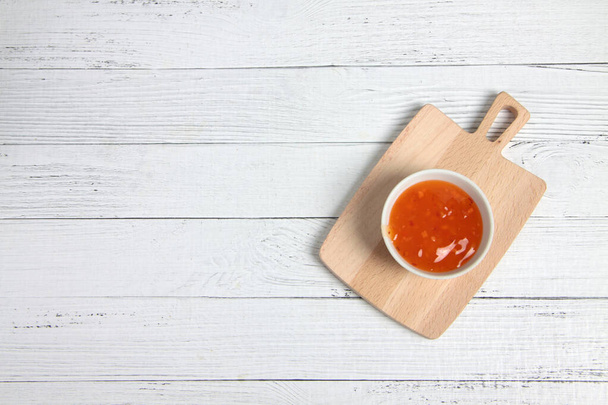 a bowl of sauce on cutting board on wooden table flat lay. Image contains copy space - Foto, Imagem