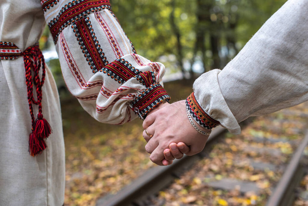 vista superior de mãos de recém-casados. noiva e noivo de mãos dadas estão na natureza no parque - Foto, Imagem