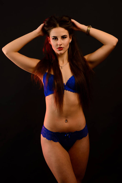 Fashion brunette woman with long dark hair in blue lingerie, isolated on dark gray background - Fotoğraf, Görsel