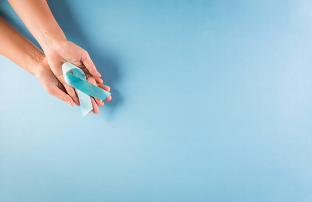 Maailman diabeteksen päivän tietoisuuden käsite. Kädessä sininen nauha, symbolinen keula väri nostaa tietoisuutta diabeteksen päivä pastellitaustalla, 14 Marraskuu. - Valokuva, kuva