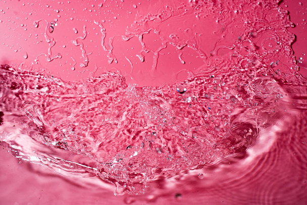 splash of water on a red background. Abstract wallpaper - Photo, image
