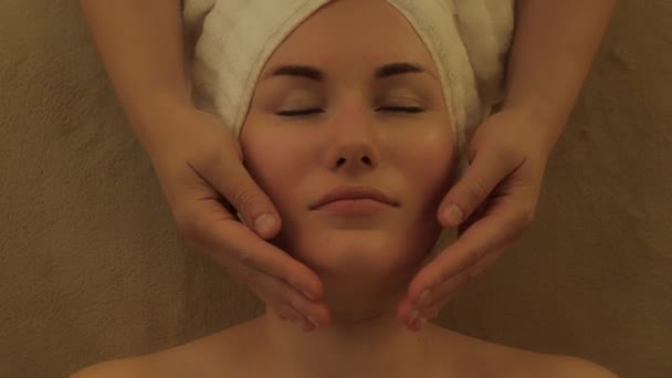 Gros plan mains féminines toucher le menton de la femme client corps peau et soins des cheveux au salon de beauté spa - Séquence, vidéo