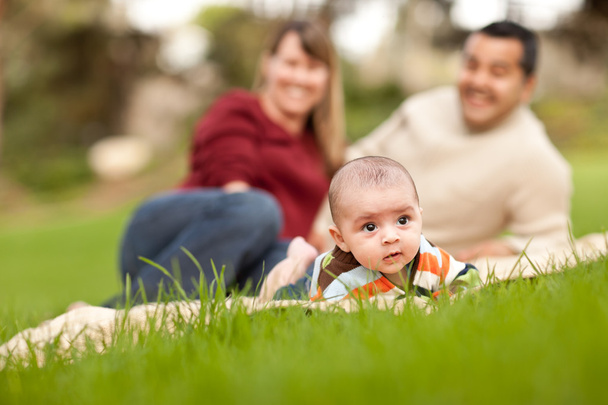Bebé feliz y padres de raza mixta jugando en el parque
 - Foto, Imagen