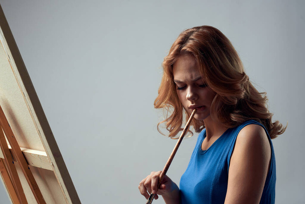 Woman artist with brush paint on easel art hobby light background - Photo, Image