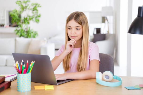 Photo of smart a-level kid girl sit table desk study remote use laptop have lesson task brainstorming solution answer touch hand chin in house indoors - Valokuva, kuva