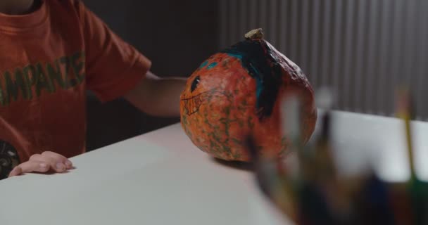Jeden chłopiec dekorowanie i malowanie dyni na Halloween - Materiał filmowy, wideo