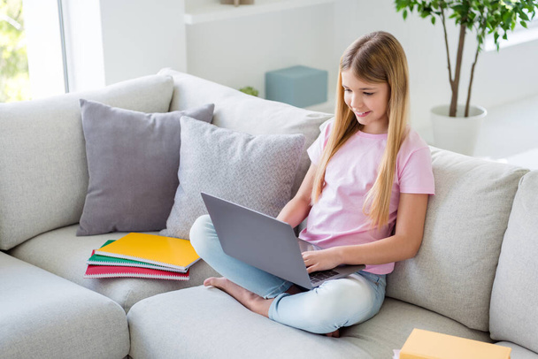 Top above high angle view full size photo of positive smart kid girl study remote use laptop watch educational video sit divan in house indoors - Foto, Imagem
