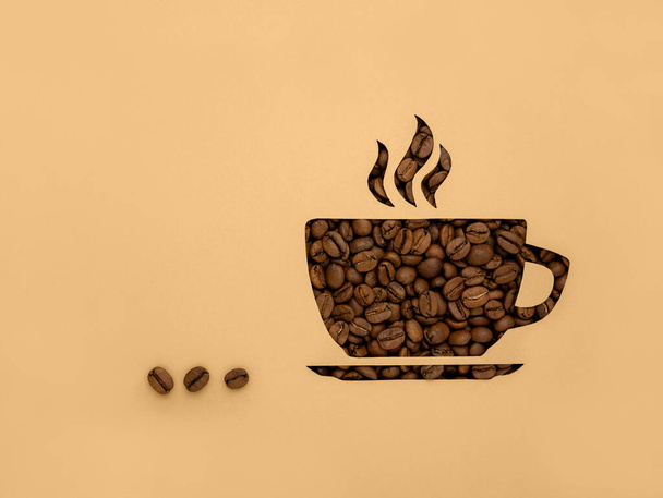 Symbolem je šálek černých aromatických kávových zrn. Pozadí s kopírovacím prostorem a místem pro text. - Fotografie, Obrázek