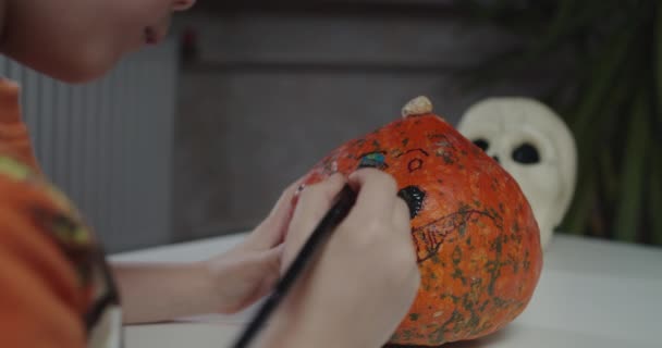 Jeden chłopiec dekorowanie i malowanie dyni na Halloween - Materiał filmowy, wideo