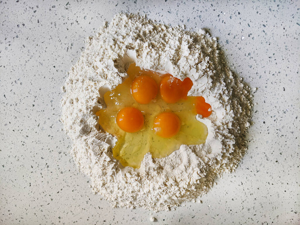 Vista superiore di uova in un fiore come un processo di cottura al forno - Foto, immagini