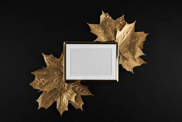 Autumn composition. Golden Frame with autumn golden maple leaves on black background. Flat lay, top view, copy space - 写真・画像