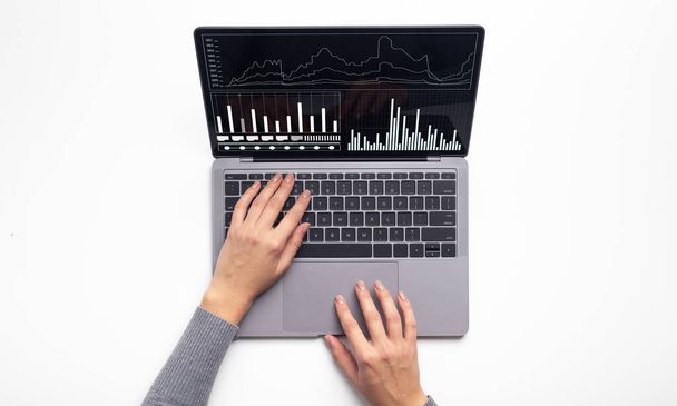 Mãos femininas digitando no computador portátil com gráficos financeiros de negócios na tela - Foto, Imagem