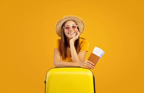 Happy young woman in sunglasses holding passport and tickets - Photo, Image