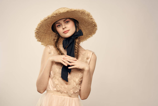 Niza chica en un sombrero de paja con una cinta negra y en un vestido sobre un fondo ligero romance modelo divertido emoción - Foto, imagen