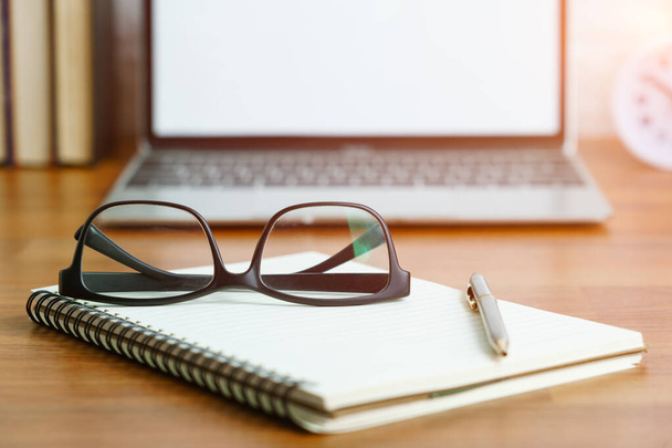 Brýle a poznámkový blok s prázdnou obrazovkou notebook na palubě, Pracoviště s notebookem na stole doma, Pracovní formulář domácí koncept - Fotografie, Obrázek