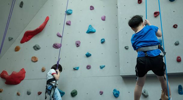 kid climbing a wall, children rock climbing - 写真・画像