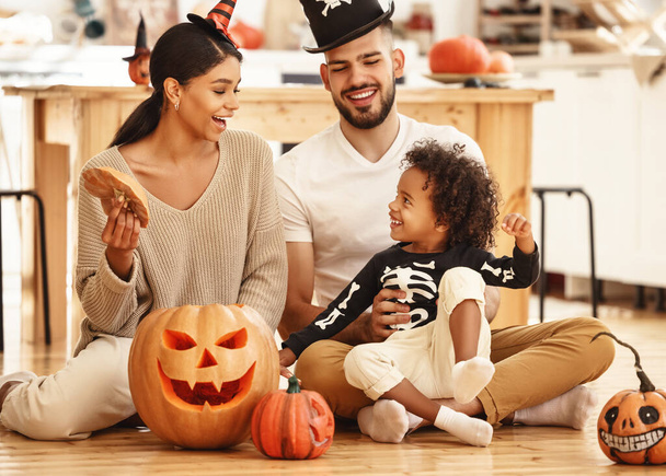 szczęśliwy wielonarodowy rodzina matka, ojciec i mały syn bawić się i świętować Halloween w hom - Zdjęcie, obraz
