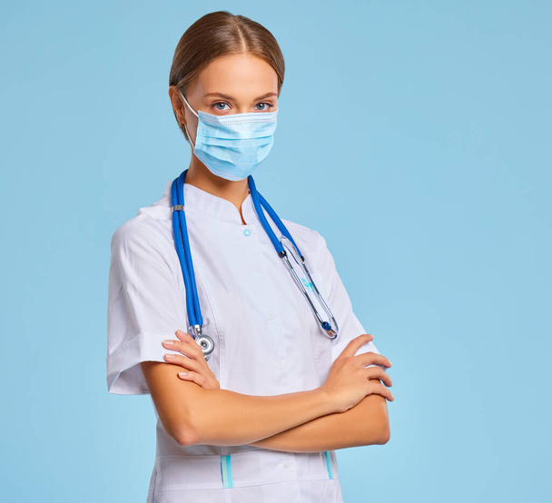 Savaş ve önleme konsepti Coronavirüs enfeksiyonu. Mutlu doktor koruyucu tıbbi maskeyi taktı.  - Fotoğraf, Görsel