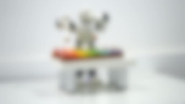 Wazige achtergrond. Een kleine robot speelt op een xylofoon close-up. - Video