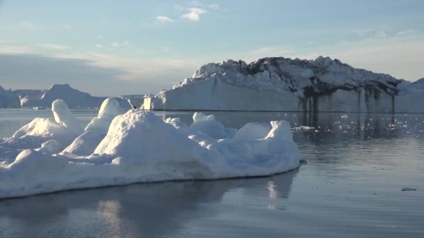 南極だ。鏡面反射の美しい青い氷山が外洋に浮かんでいます。背景には夕焼け空。雄大な冬の風景。旅行 - 映像、動画