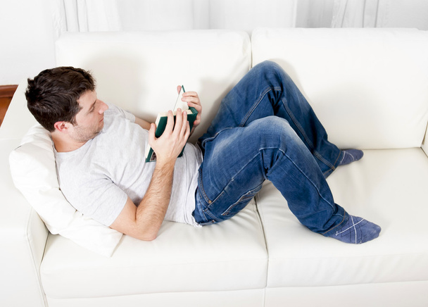 attractive man reading book or studying on couch - Foto, immagini