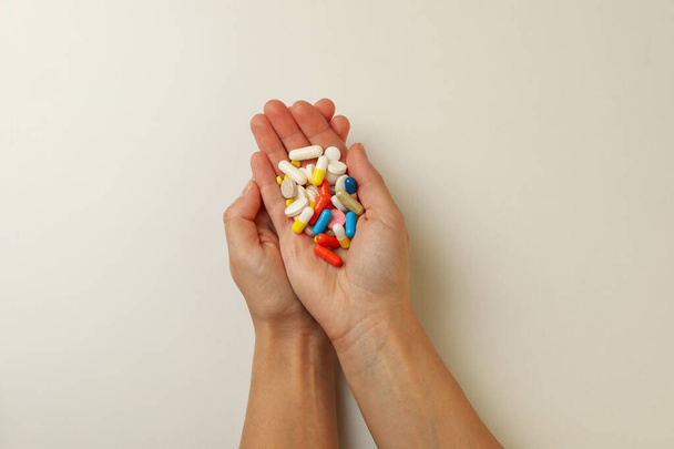 Female hands hold different pills on white background - Foto, Bild