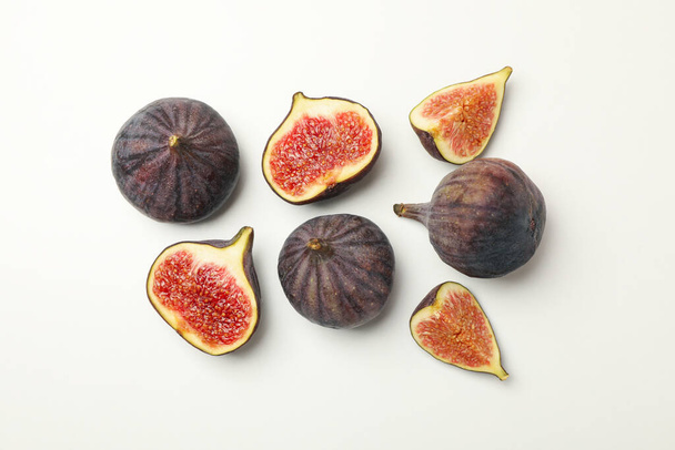 Свіжі інжирні фрукти та скибочки на білому тлі, вид зверху
 - Фото, зображення
