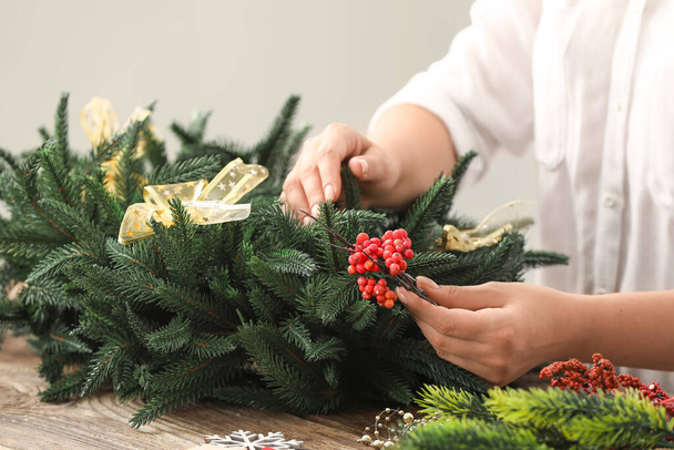 Woman making beautiful Christmas wreath on table - Zdjęcie, obraz