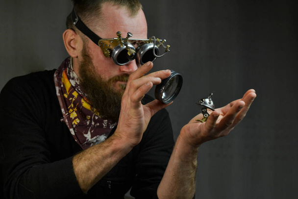 Steampunk uomo indossando occhiali e mantenendo robot - Foto, immagini