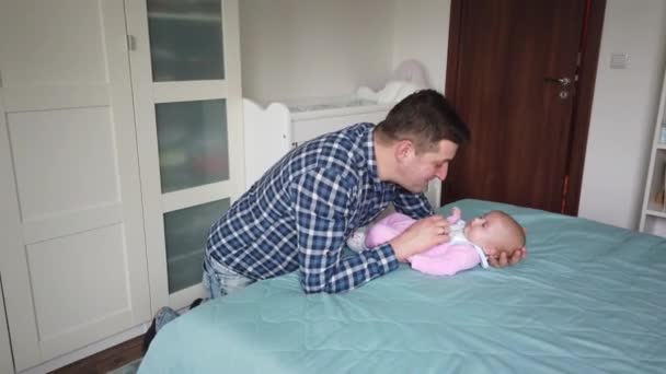 Feliz padre jugando con un bebé en casa. Familia, concepto de paternidad - Imágenes, Vídeo