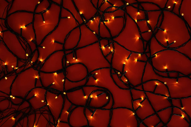 Светящиеся рождественские огни на цветном фоне - Фото, изображение