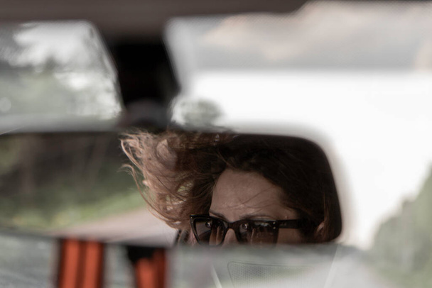 girl is driving car. the wind is blowing through the window - Φωτογραφία, εικόνα