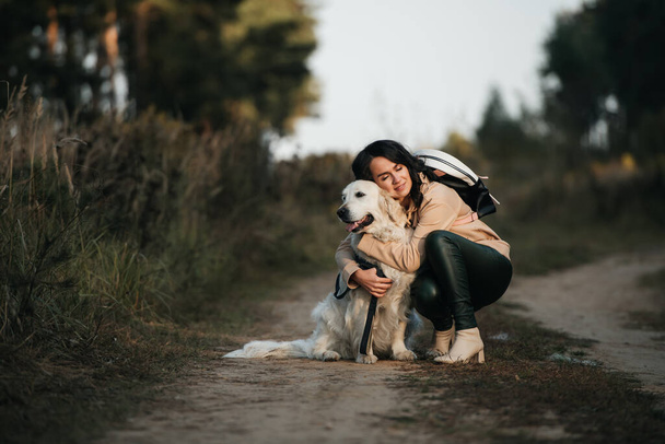girl hugging a golden retriever dog in the forest - Foto, Imagem