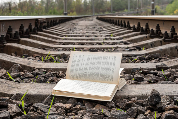 Gros plan d'un livre ouvert sur les voies ferrées, la campagne. - Photo, image