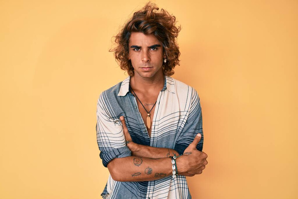 Young hispanic man wearing summer style skeptic and nervous, disapproving expression on face with crossed arms. negative person.  - Photo, Image